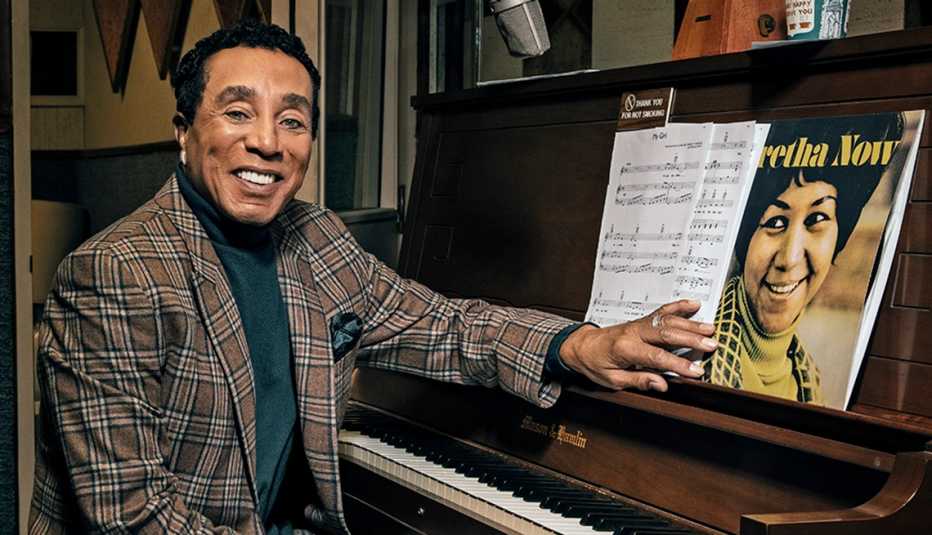 Smokey Robinson sitting in front of a piano