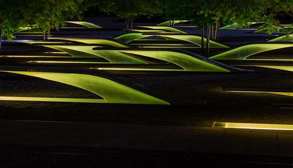 Cantilevered bench memorial and lighted pool part of the Pentagon Memorial at night