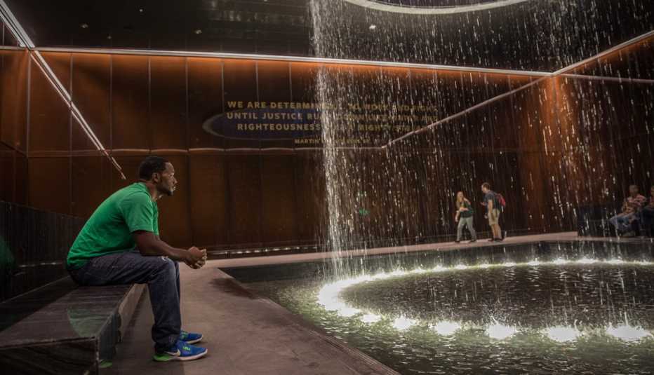a man sitting in the contemplative court at the national museum of african american history and culture in washington d c