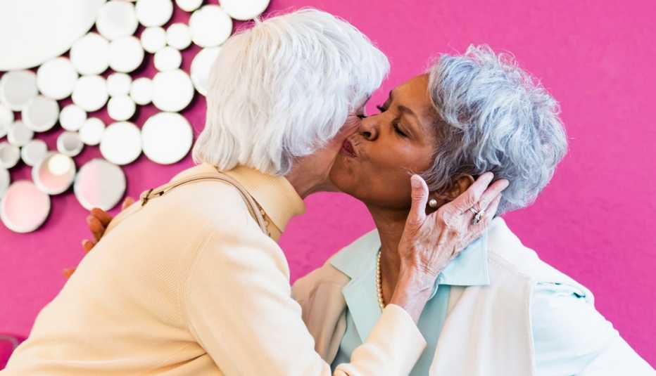 two women exchange air kisses on the cheek as a greeting