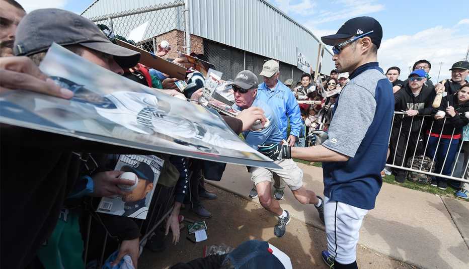 Ichiro Suzuki of the Seattle Mariners signs autographs for fans during a spring training camp at Peoria Sports Complex 