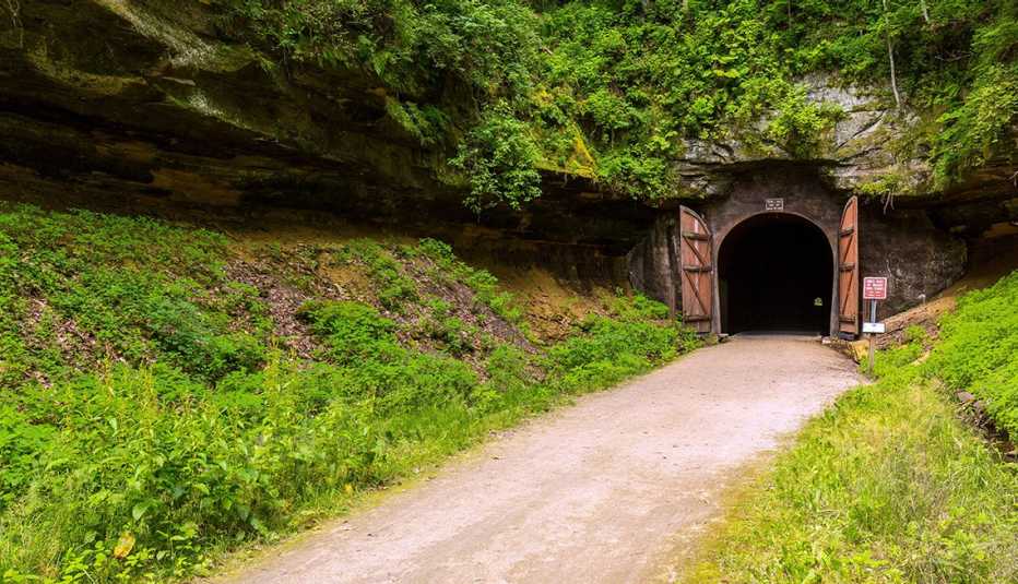 a bike trail leading into a tunnel that was formerly part of a railroad