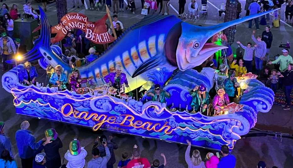 a float with a giant fish in the orange beach mardi gras parade