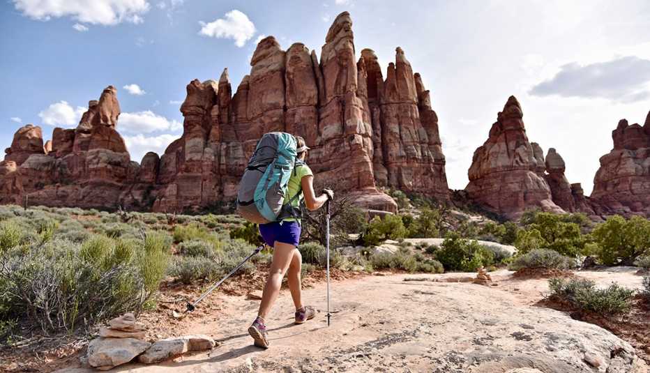 a woman hiking near the needles rock formation in canyonlands national park utah