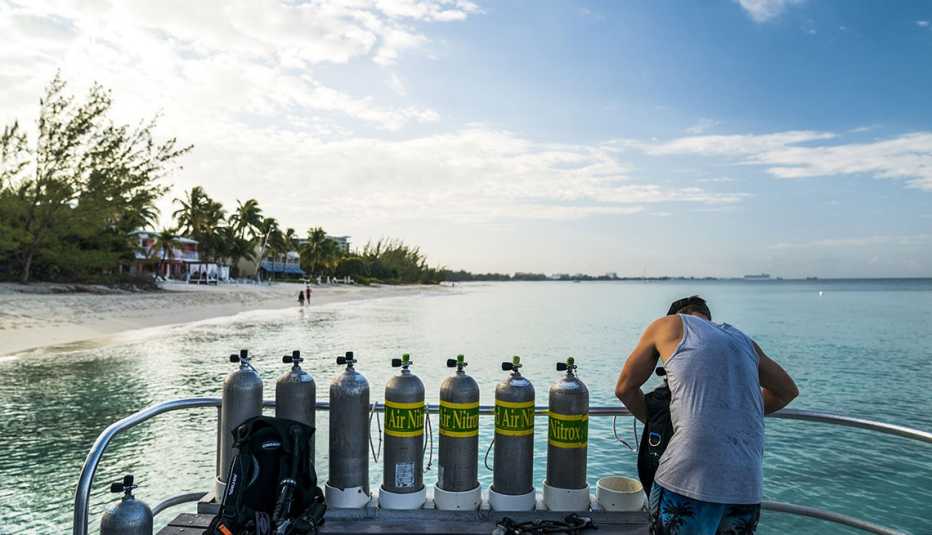 a man checking dive equipment on the coast of the grand cayman island