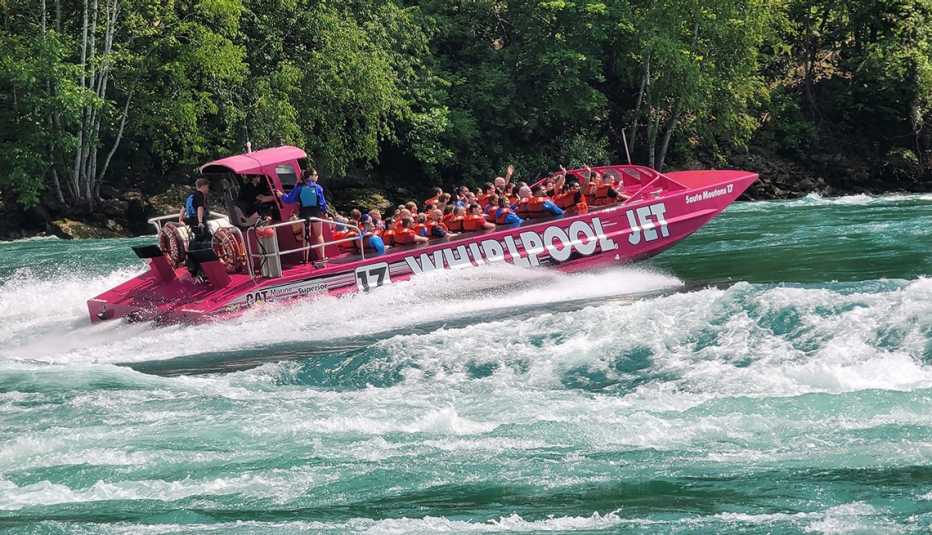 A group of tourists enjoy a sightseeing cruise with Whirlpool jet boat tours.