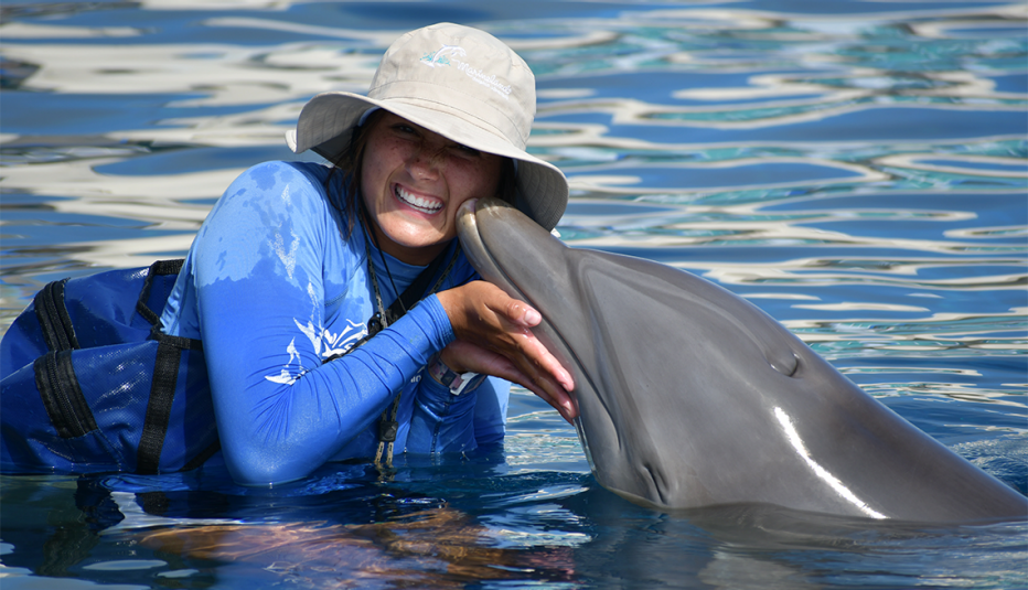 A woman at Marineland in Florida getting a kiss from a dolphin