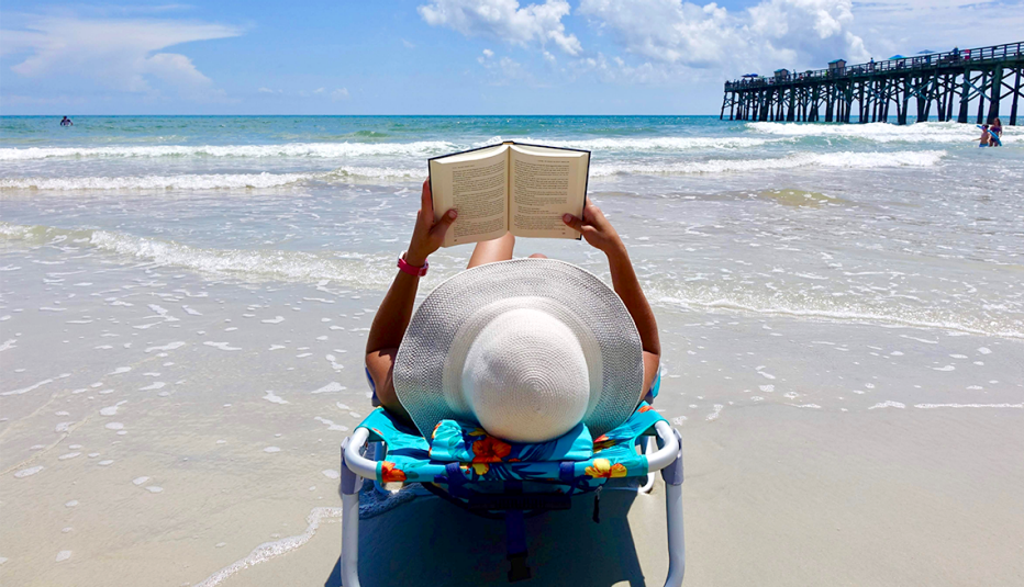 A woman reading a book by the ocean in Flagler Beach, Florida