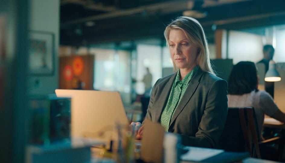 woman in suit at desk in front of computer