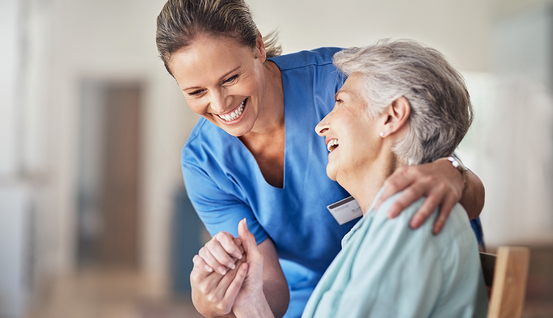 a nurse holds an older woman's hand