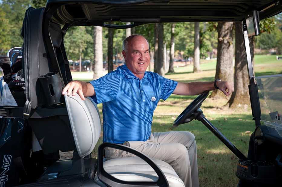 karl yergey in the drivers seat of a golf cart