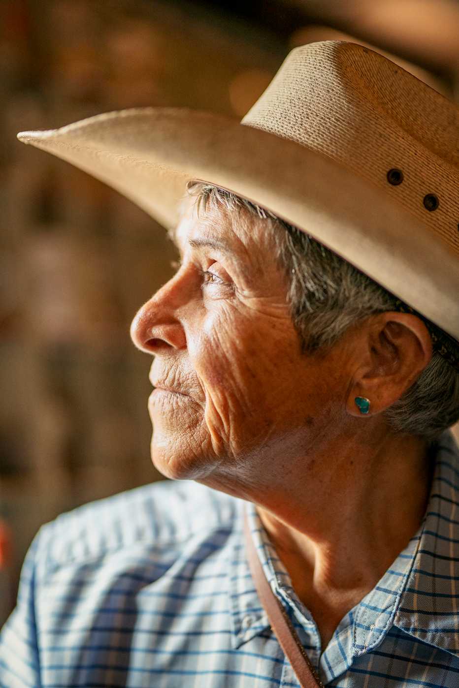 close up portrait of a woman in a cowboy hat gazing into the distance