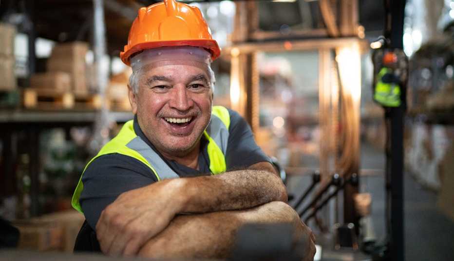 A man is smiling while sitting on a forklift