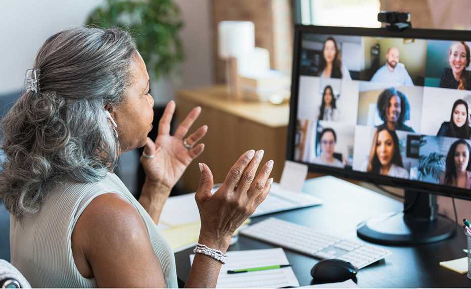 a woman working from home talks to colleagues over a video call