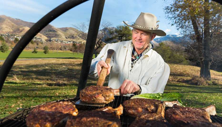 Mike Bertelsen flips a steak cooking over a cauldron