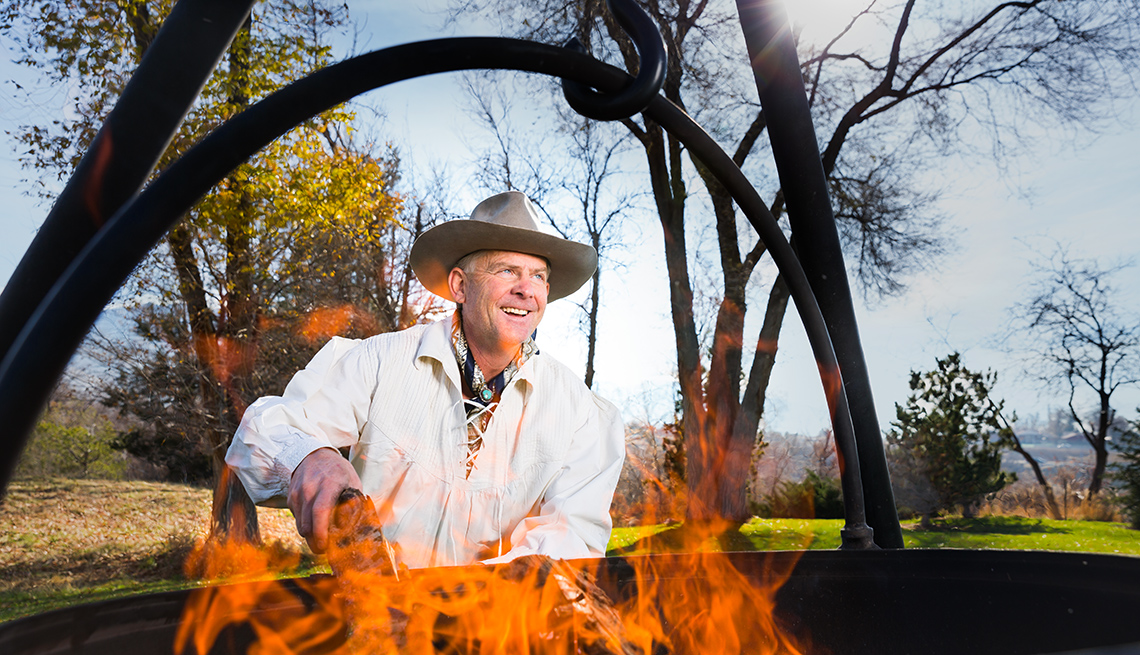 Mike Bertelsen, founder of Cowboy Cauldron, adds wood to a cauldron fire