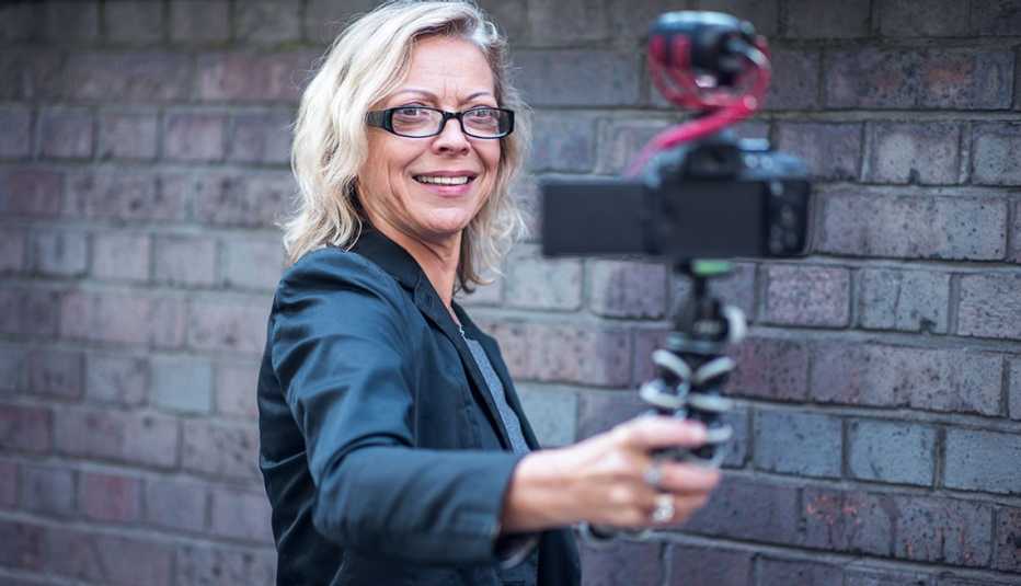 Professionally dressed, smiling woman taking video of herself