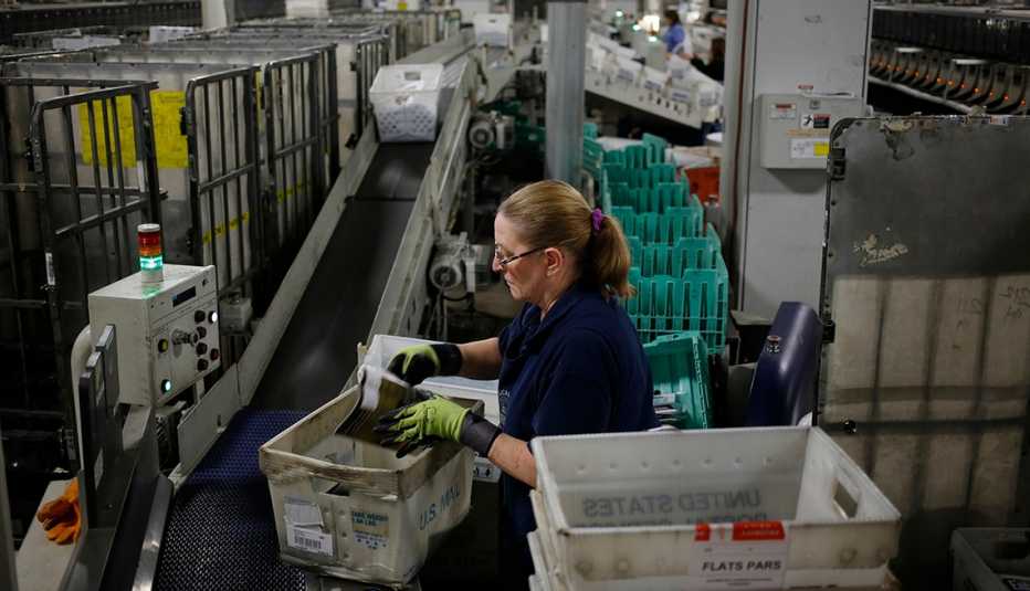 A worker sorts mail at a postal facility