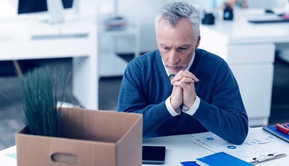 A man sitting at his desk looking at a box