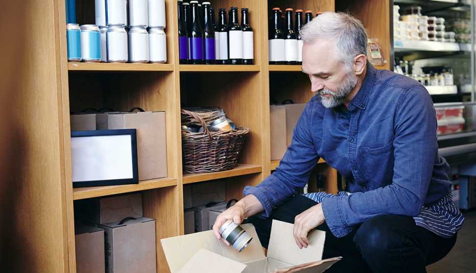 Older man putting away products on a store shelf