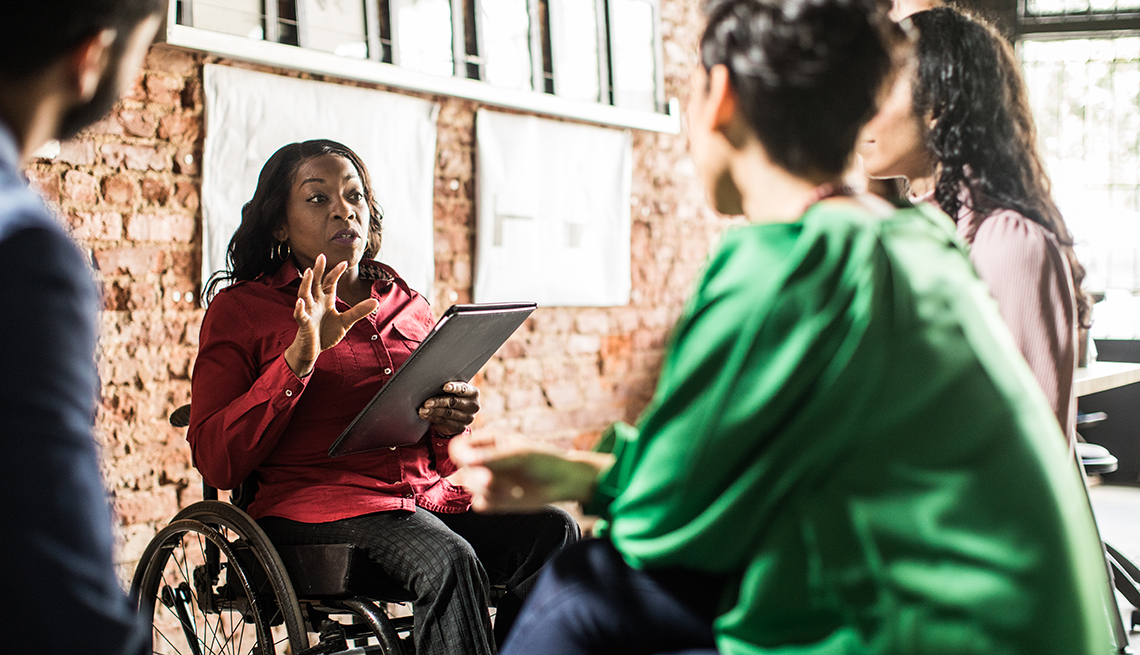 Businesswoman in wheelchair leading group discussion in office