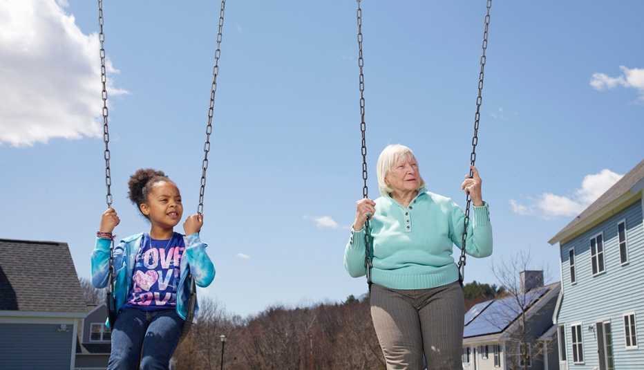 Mary Steele, right,  swings with a foster child at Treehouse Community in Massachusetts. 