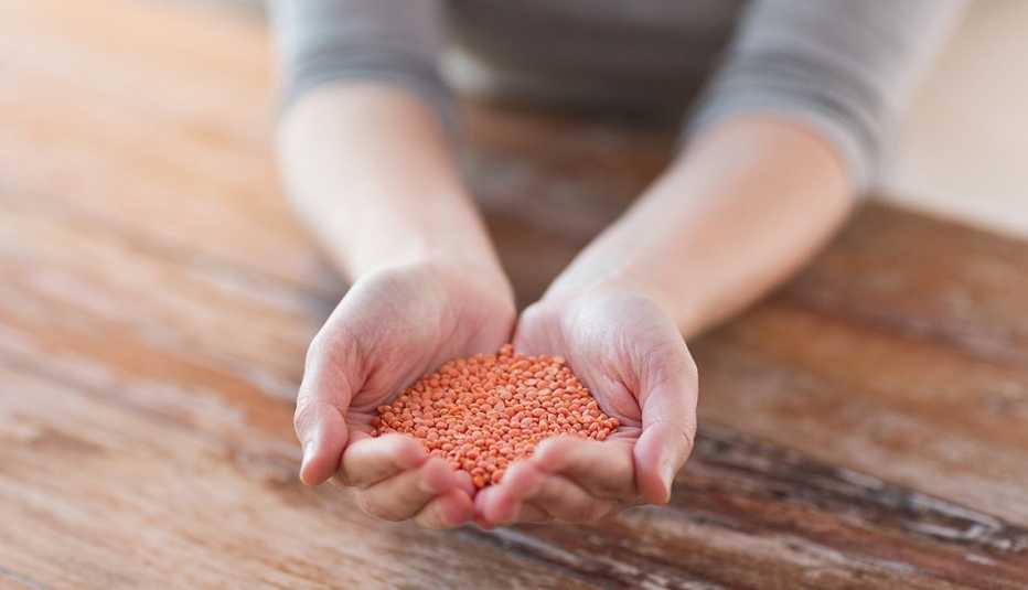 Persona tiene las manos llenas de quinoa
