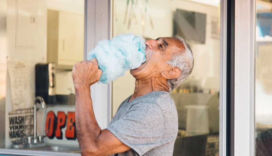 Un hombre comiendo algodón de azúcar