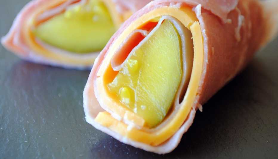 Detalle de un enrollado de jamón, queso y pepinillo