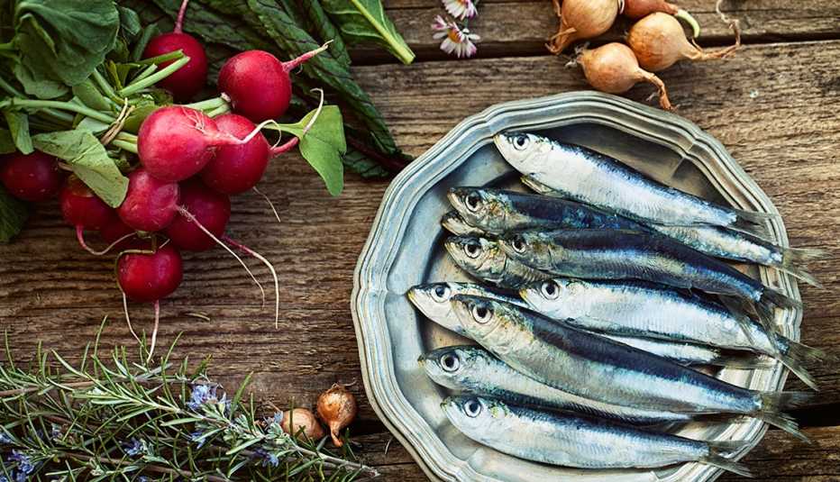 Plato de sardinas rodeado de vegetales
