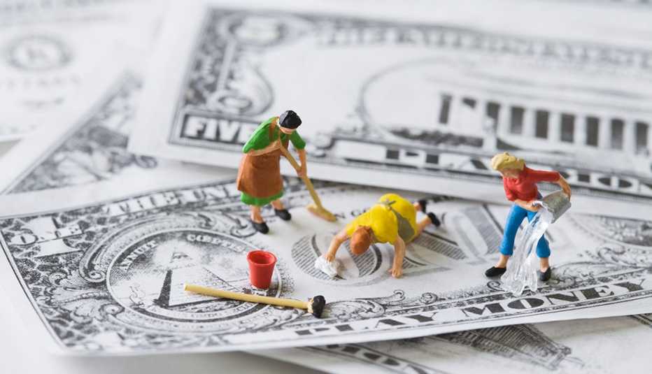 Figuras miniatura limpiando billetes de dólar y aprende del poder de tu dinero