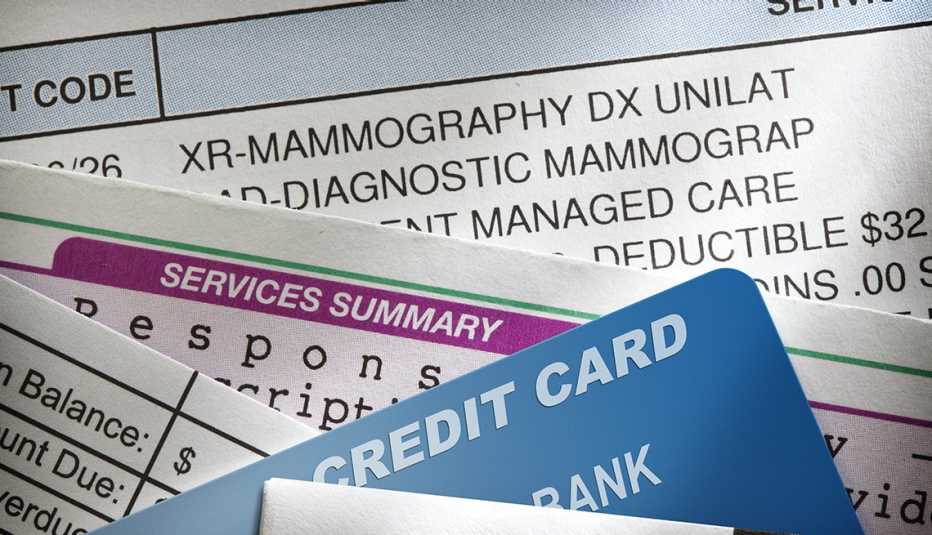 Varias facturas médicas debajo de una tarjeta de crédito