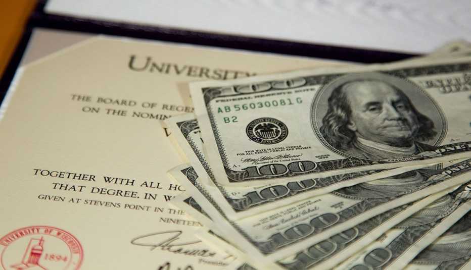 Dólares sobre un diploma universitario.