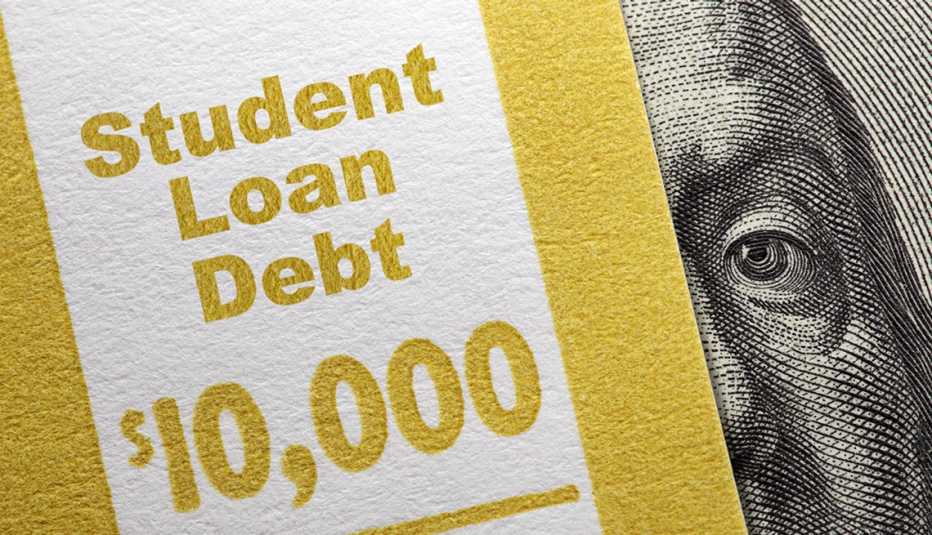 Parte de un billete de 100 dólares con un ojo de Benjamin Franklin cubierto bajo un texto que dice deuda de préstamo estudiantil  10 mil