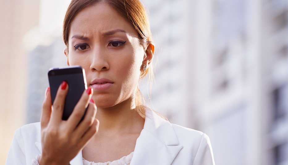 Mujer mirando a un teléfono móvil