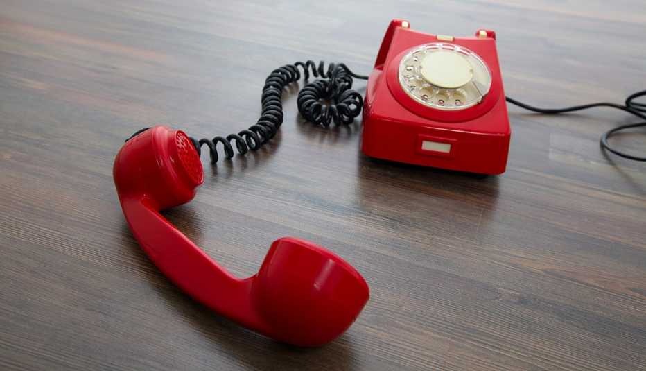 Teléfono rojo y antiguo en el piso