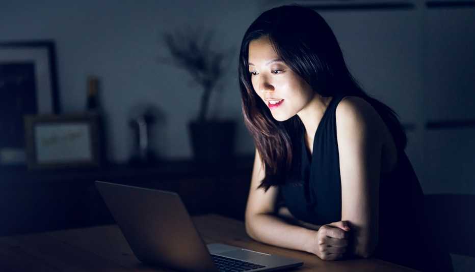 Mujer asiática mirando a su computadora.