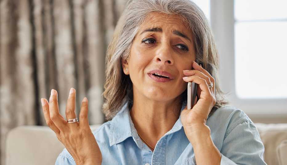 Mujer frustrada al recibir una llamada no deseada en su casa.