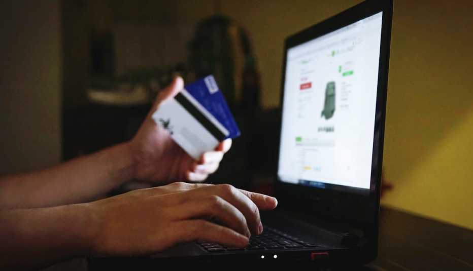 Persona usa una tarjeta de crédito para comprar por internet