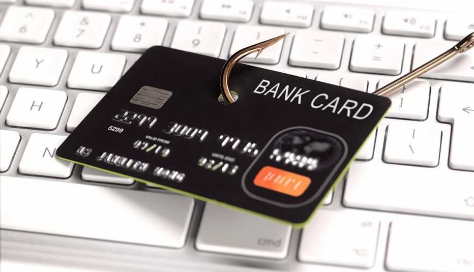 Tarjeta de crédito con un gancho, que se muestra en un teclado que significa estafa de phishing