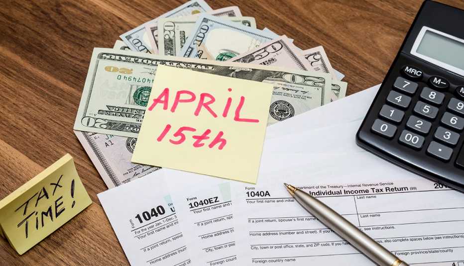 Formulario de impuestos 1040 con una nota adhesiva del 15 de abril
