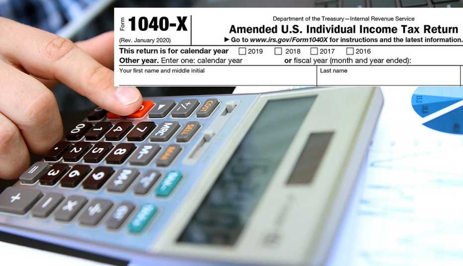 Mano de una persona haciendo cuentas en una calculadora y la parte superior del formulario 1040 del IRS