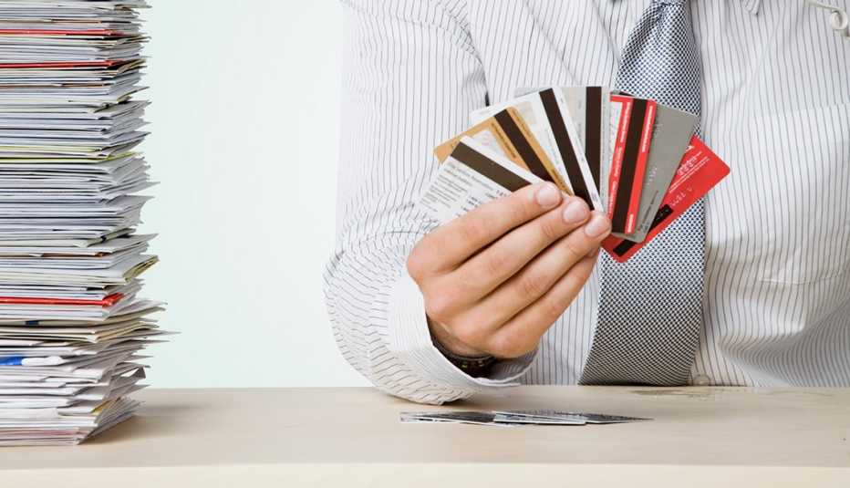 Hombre sosteniendo tarjetas de crédito en la mano - Errores frecuentes al comprar un negocio