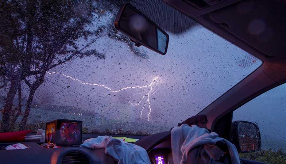 Un rayo resplandece en el cielo, visto desde el interior de un auto