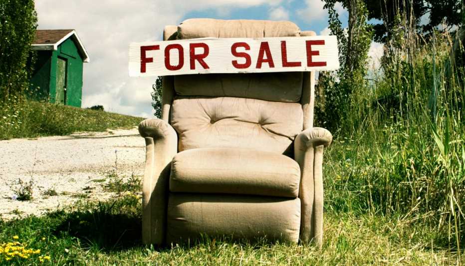 Una silla vieja en un patio con un letrero en inglés que dice se vende