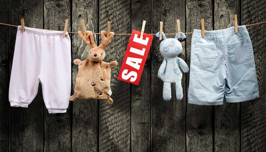 juguetes de peluche usados, pantalones para niños y un cartel de venta, colgados de clips para ropa
