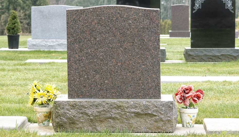 Lápida de un cementerio con flores alrededor
