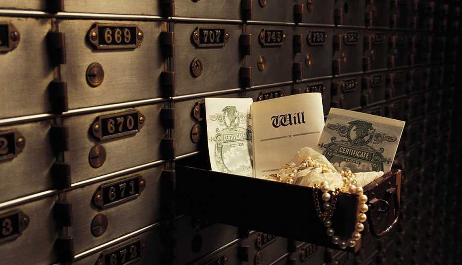 Caja de seguridad abierta con joyas y bonos en una bóveda de un banco.