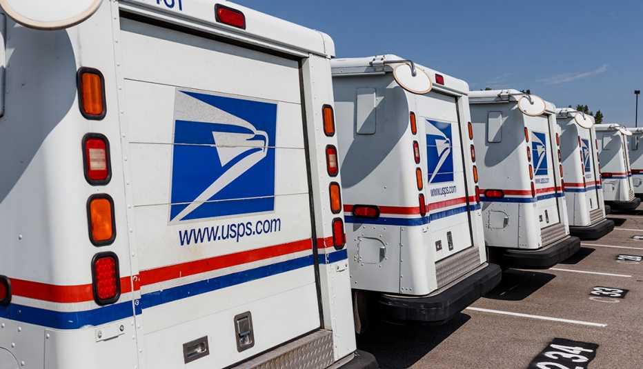 Camiones de la oficina de correos de Estados Unidos alineados en un estacionamiento