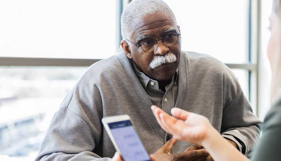 Persona mayor recibiendo información acerca de un préstamo en una cooperativa